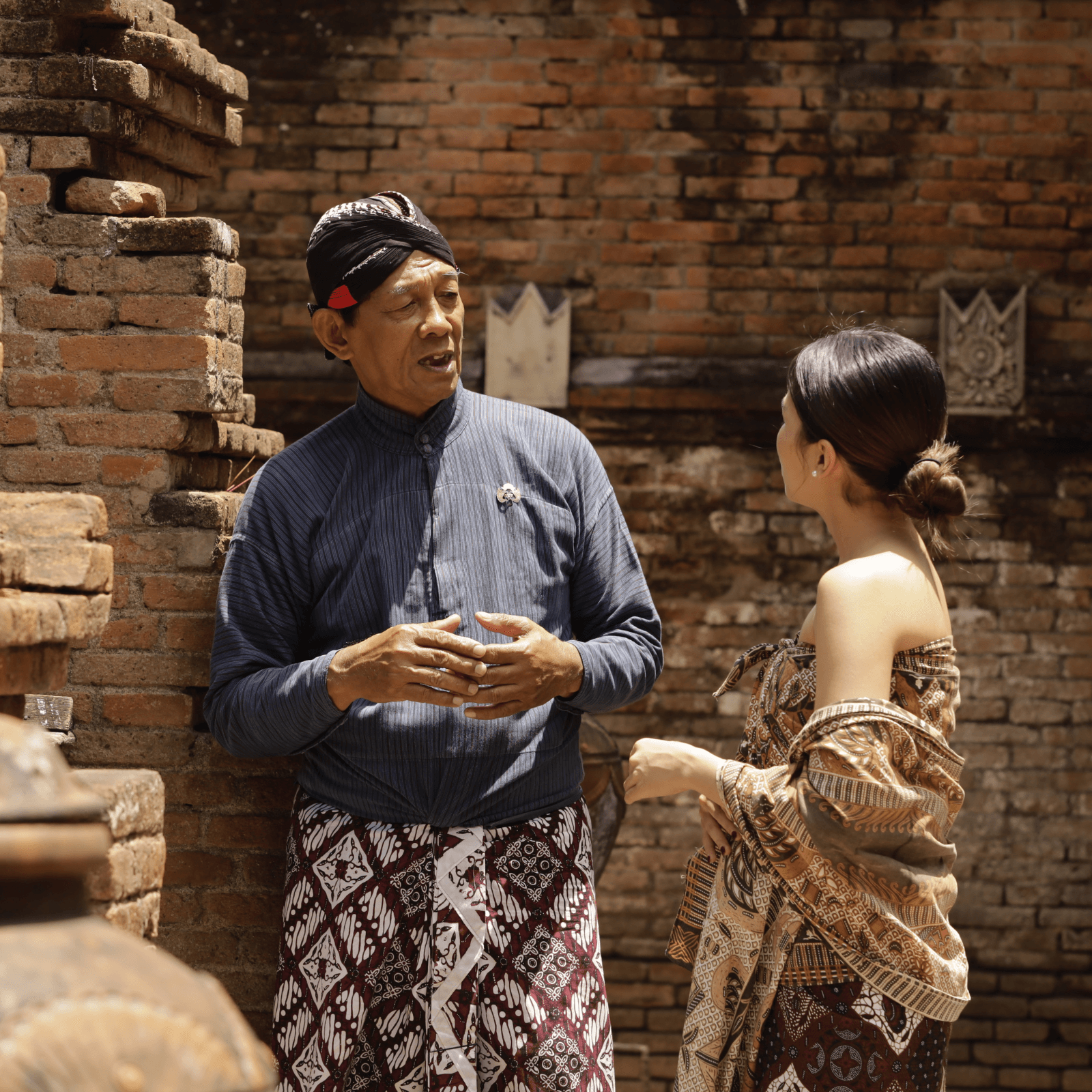 A man explaining Kota Gede history to a woman